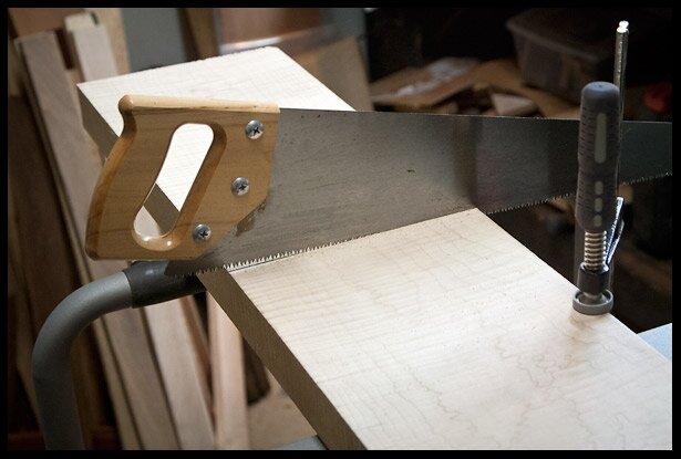 Hand sawing a piece of flamed maple