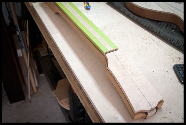 The neck and headstock templates are held in place with masking tape and super glue