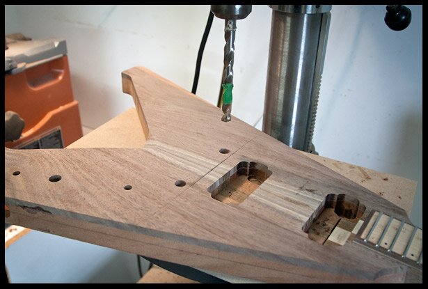 Once the neck is glued in, I calculate and drill the holes for bridge posts