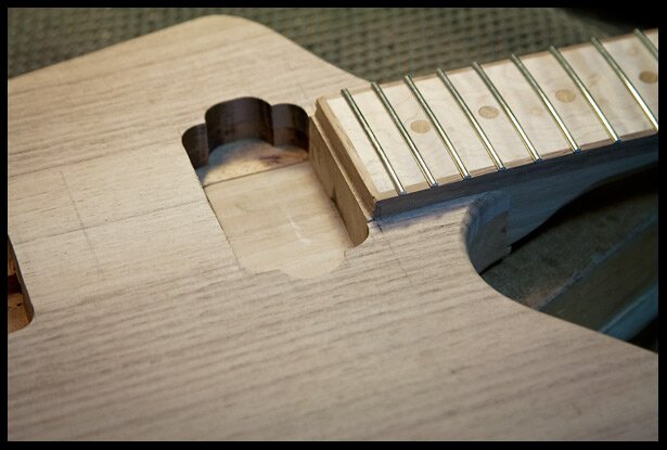 The neck heel in the neck pocket with humbucker cavity