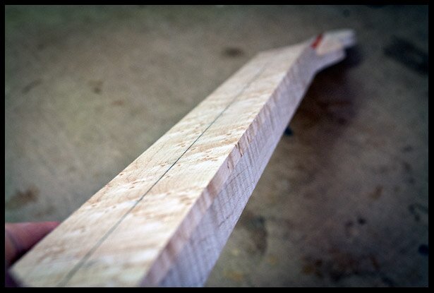 The truss rod and fingerboard are installed on the neck